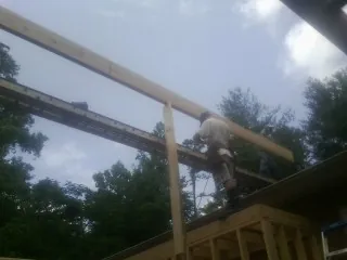 Carpenter setting a ridge beam over a new addition frame — Ice Dam Removal by Roofing Brothers in Brockway
