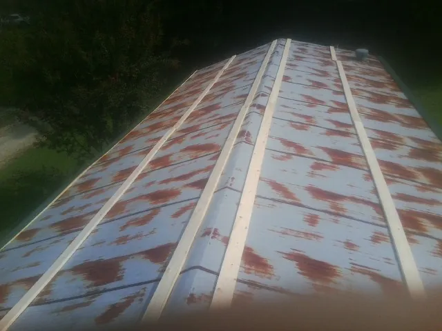 Rusted metal roof panels with new wood purlins before replacement — Storm Damage Roof Repair in Brockway by Roofing Brothers